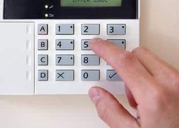 An image of someone setting an alarm system for security.