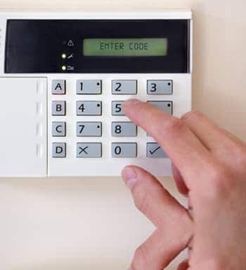 An image of someone setting an alarm system for security.