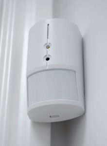 An image of a white plastic alarm sensor used in a home