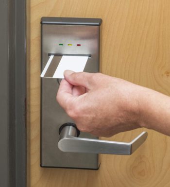 An image of a key card being used to open a door that uses access control systems