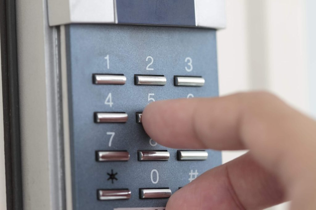 A close up image of a hand tapping numbers of a pin entry system.