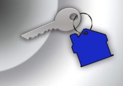 An image showing a silver key with a blue keyring the shape of a house attached.