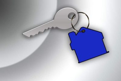 An image showing a silver key with a blue keyring the shape of a house attached.