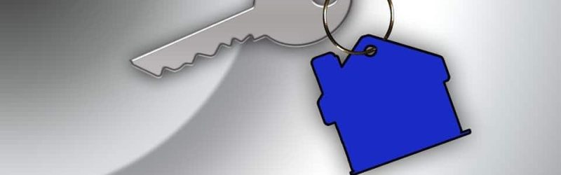 An image showing a silver key with a blue keyring the shape of a house attached.