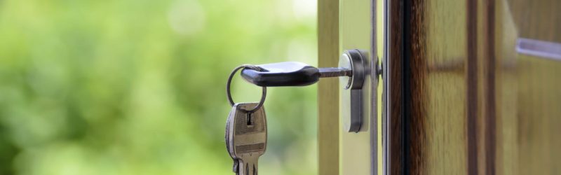 Keys in a lock on an open front door