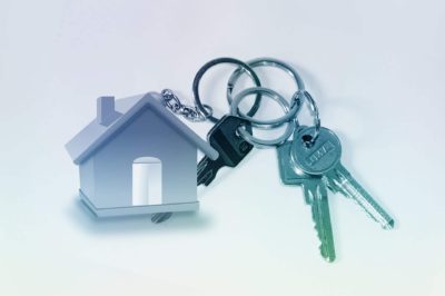 An image of a bunch of keys with a keyring in the shape of a house attached.