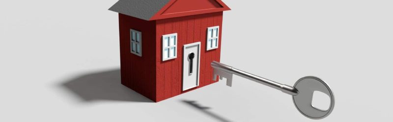 An image of a key being inserted into the door of a house.